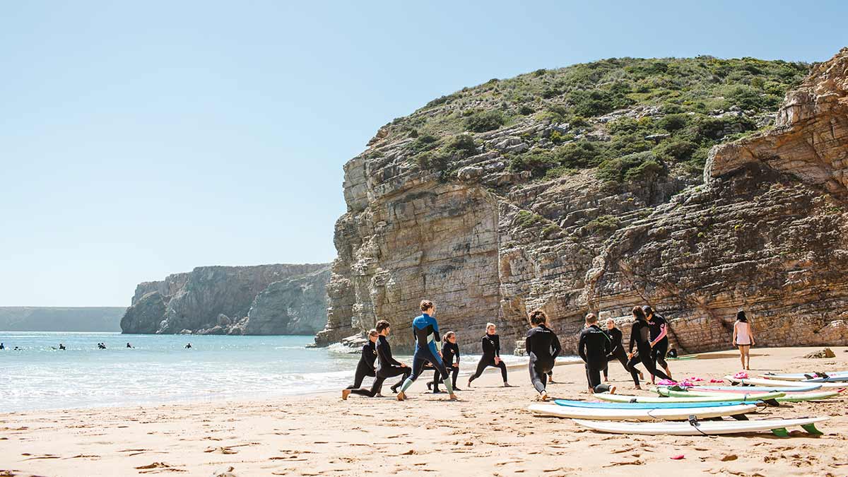 Group Stretching On The Beach Before Surfing At Good Feeling Surf School